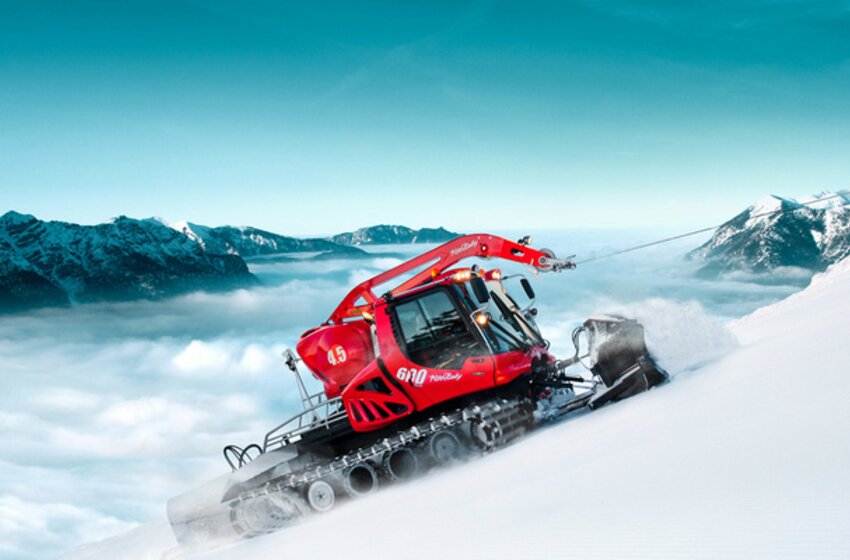 Rote Pistenraupe mit Seilwinde fährt steilen Hang in Alpen hinauf | © Hochkönig Bergbahnen GmbH