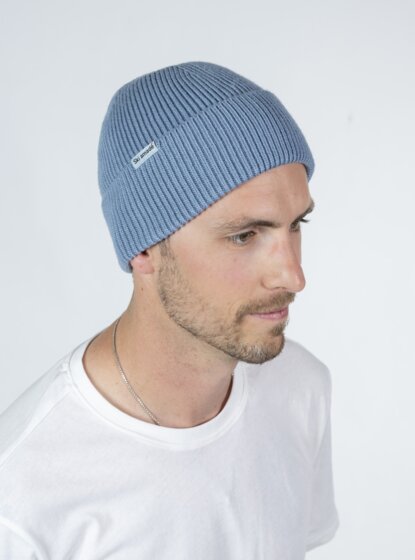Mann im weißen Shirt mit hellblauer Ski amadé Mütze im Profil vor hellem Hintergrund | © Ski amadé GmbH / Lorenz Masser