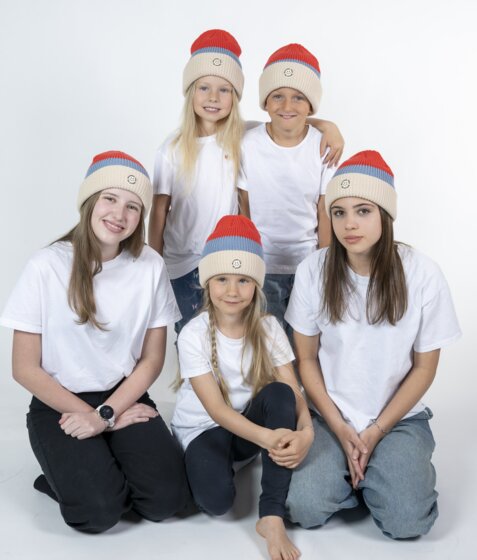Fünf Kinder mit roten Mountain Vibe Ski amadé Mützen und weißen Shirts im Studio | © Ski amadé GmbH / Lorenz Masser